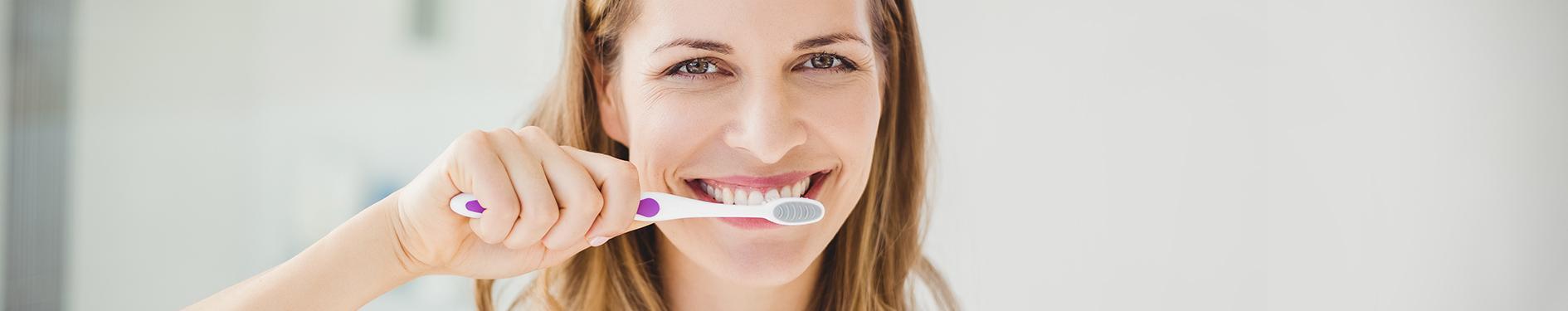 Uśmiechnięta kobieta myjąca zęby